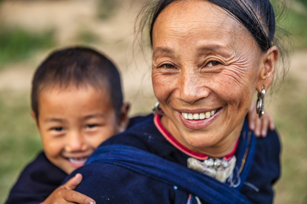 Laotian mother carrying her little son, village in Northern Laos